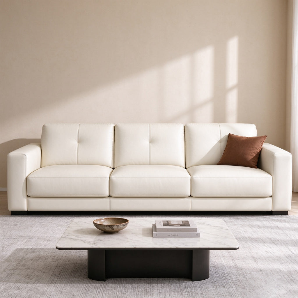 The sofa in a warm room with a marble coffee table, a brown cushion and soft window light