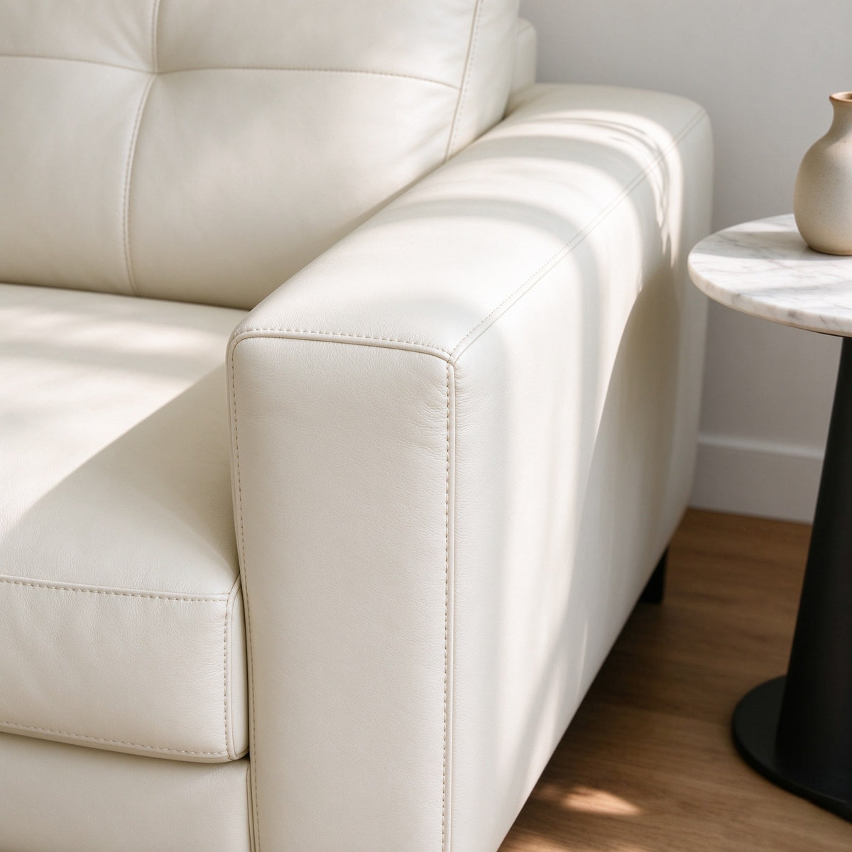 Close-up of the square leather arm and stitched cushion edges