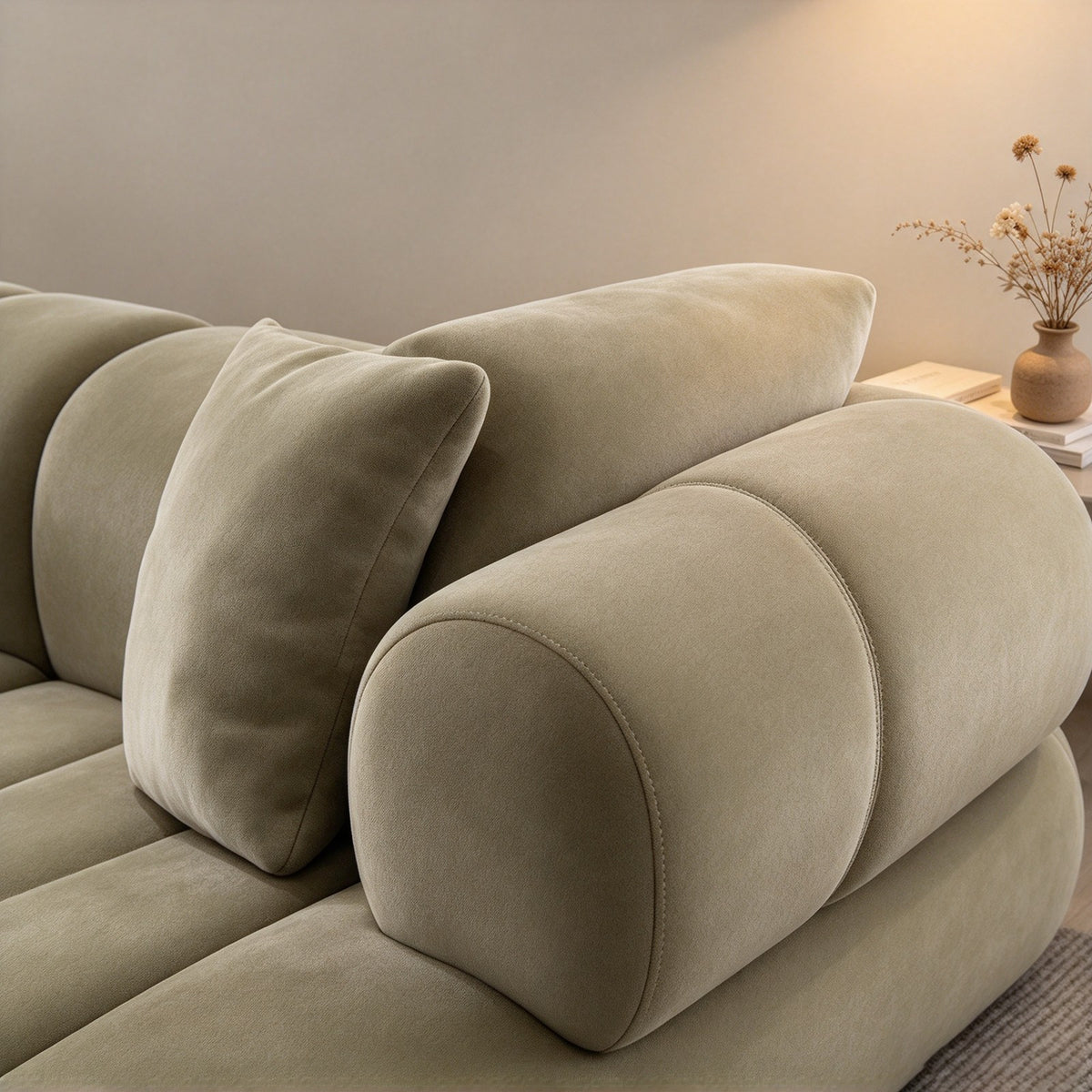 Close-up of the rounded segment cushions and rolled arm in sage velvet