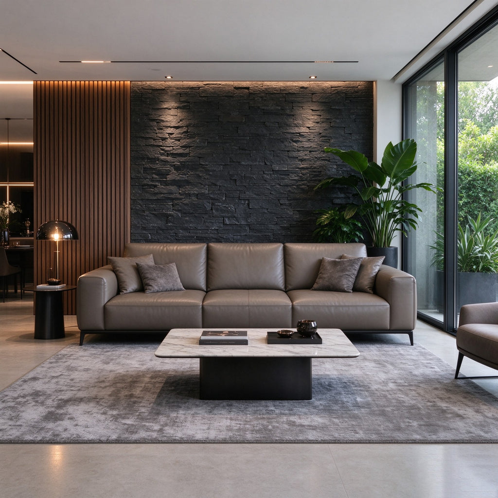 The sofa in a dark stone and timber living room with a marble coffee table and a grey rug