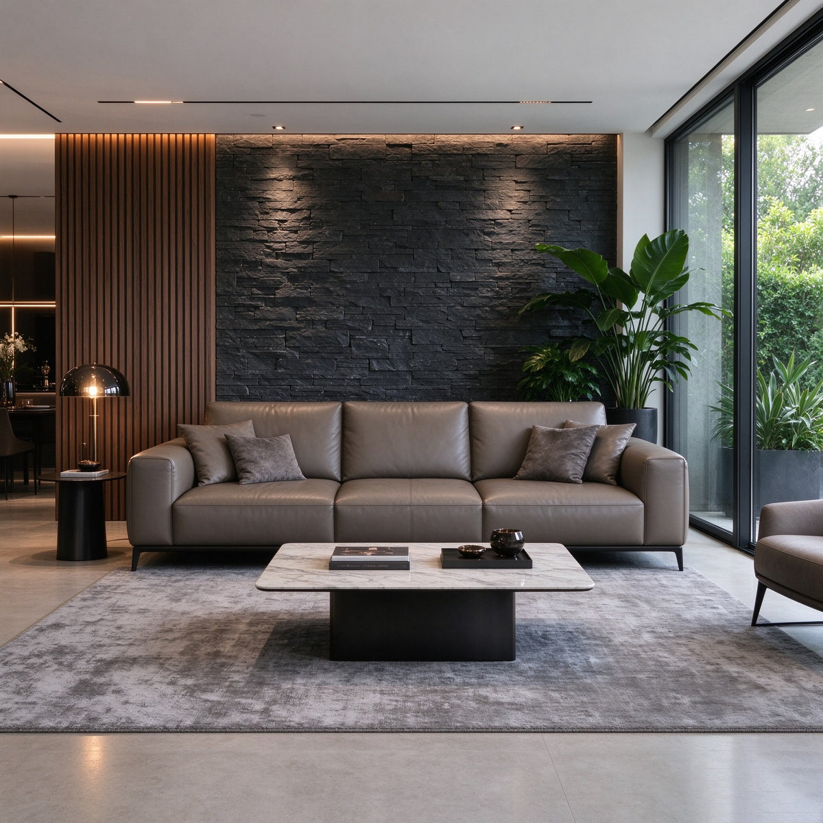The sofa in a dark stone and timber living room with a marble coffee table and a grey rug